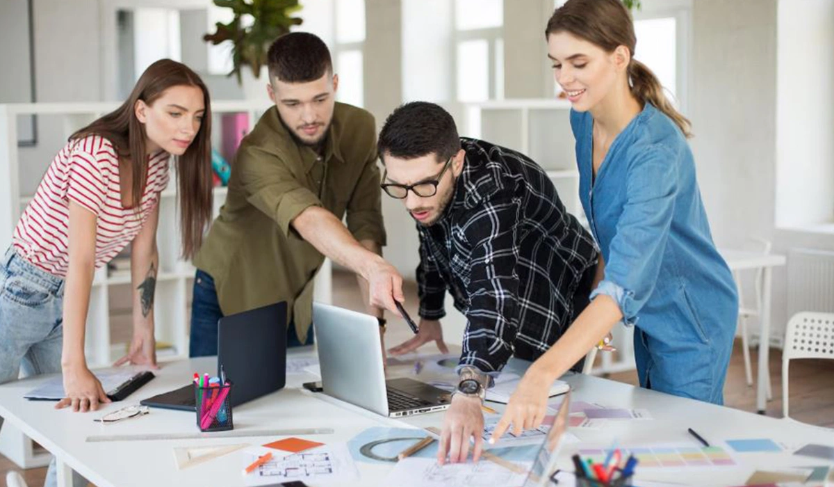 architecture studio team planning project around laptop and design documents